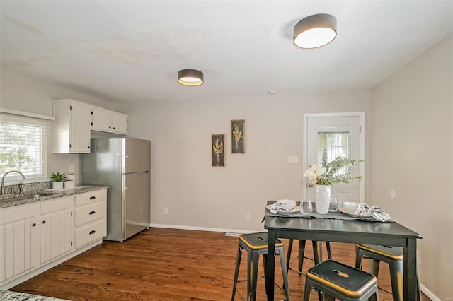 kitchen with a wealth of natural light, sink, dark hardwood / wood-style floors, and white cabinetry