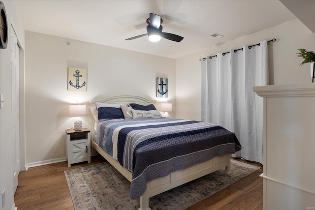 bedroom with a closet, ceiling fan, and dark hardwood / wood-style flooring