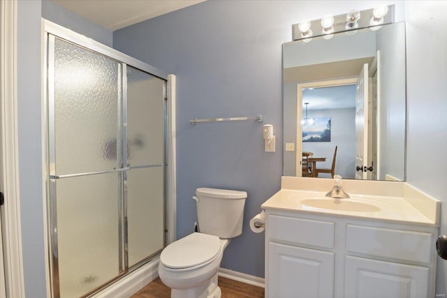 bathroom featuring an enclosed shower, hardwood / wood-style floors, toilet, and vanity