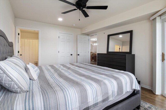 bedroom featuring ensuite bath, wood-type flooring, and ceiling fan