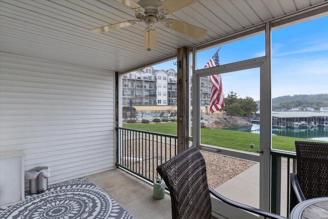 sunroom / solarium featuring a water view, ceiling fan, and a healthy amount of sunlight