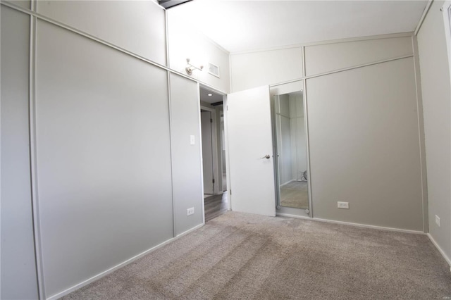 unfurnished bedroom featuring lofted ceiling, a closet, and carpet flooring