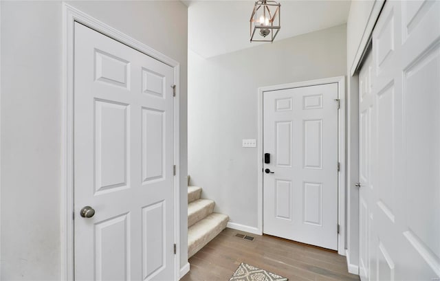 foyer featuring light wood-type flooring and a chandelier