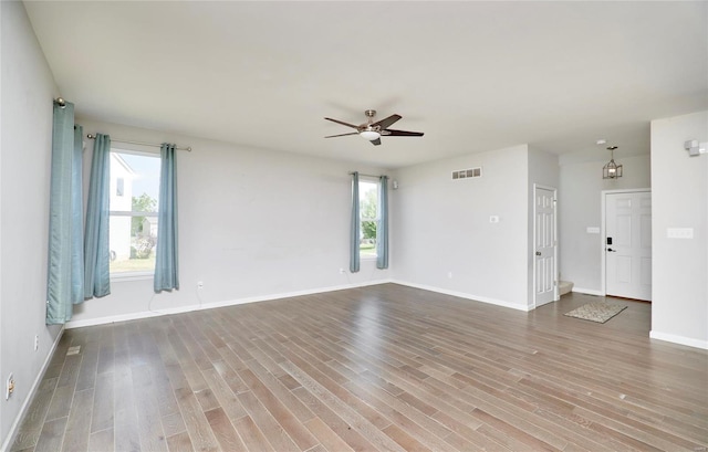 empty room with hardwood / wood-style floors and ceiling fan