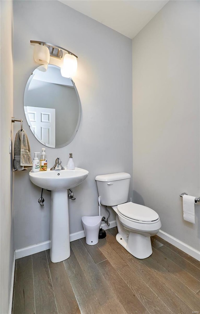 bathroom featuring wood-type flooring, toilet, and sink