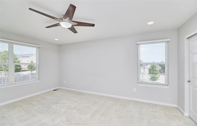 carpeted empty room featuring a healthy amount of sunlight and ceiling fan