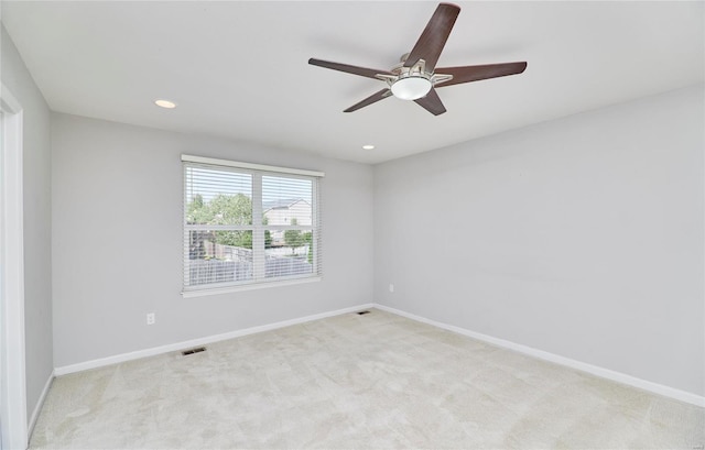 spare room with light colored carpet and ceiling fan