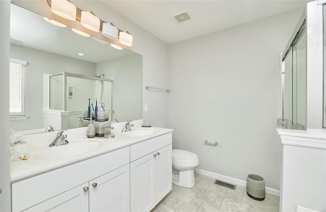 bathroom featuring a shower with shower door, toilet, and vanity