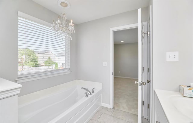 bathroom featuring tile patterned flooring, a bathtub, an inviting chandelier, and vanity