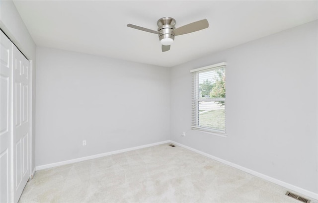 unfurnished bedroom with light carpet, ceiling fan, and a closet