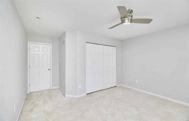 unfurnished bedroom with light colored carpet, ceiling fan, and a closet