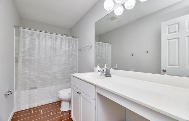 bathroom featuring vanity, toilet, hardwood / wood-style floors, and walk in shower