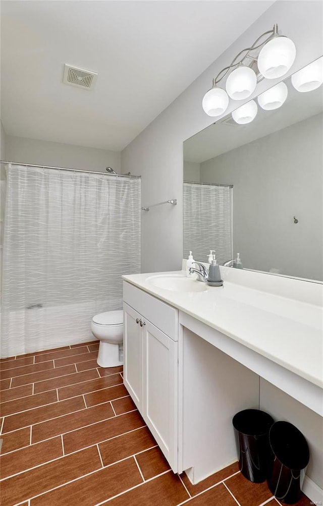 bathroom with curtained shower, toilet, and vanity