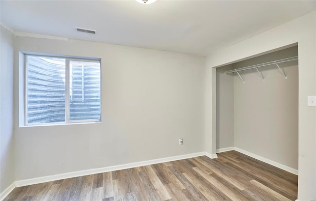 unfurnished bedroom with hardwood / wood-style flooring and a closet