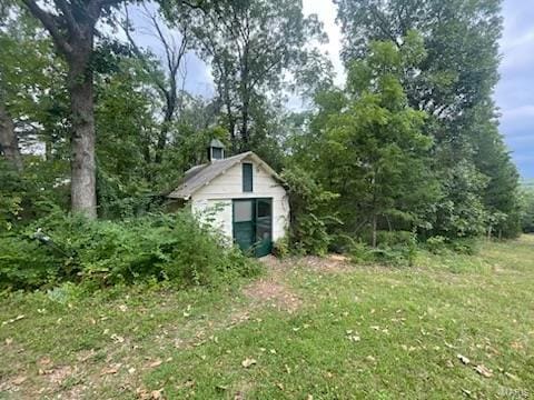 view of home's exterior with a yard and a shed