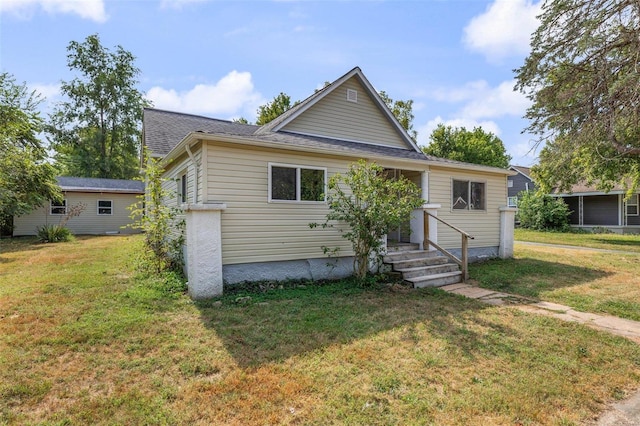 bungalow-style home with a shingled roof and a front yard