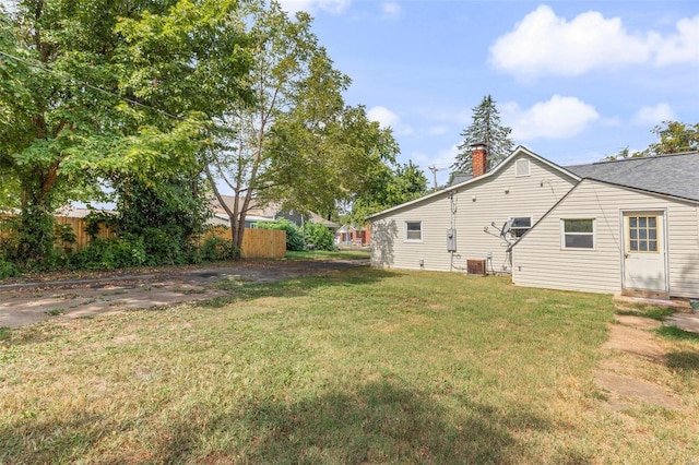 view of yard with central AC and fence