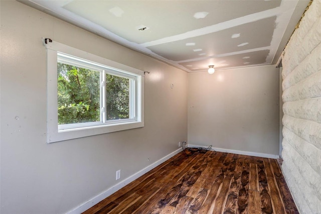 spare room with hardwood / wood-style floors and baseboards
