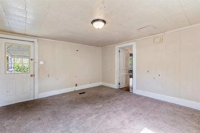 unfurnished room with carpet, visible vents, and baseboards