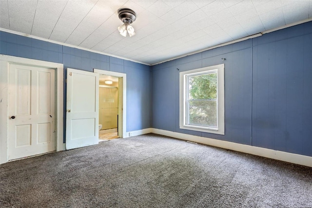 unfurnished bedroom featuring connected bathroom, crown molding, and carpet floors