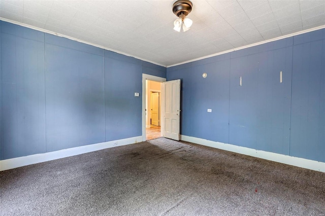 carpeted empty room featuring ornamental molding and baseboards