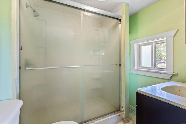 bathroom featuring vanity, toilet, and a shower with door