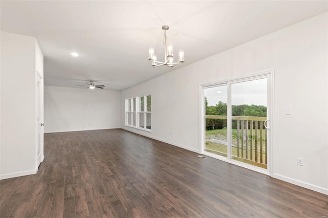 unfurnished room featuring ceiling fan with notable chandelier and dark hardwood / wood-style floors