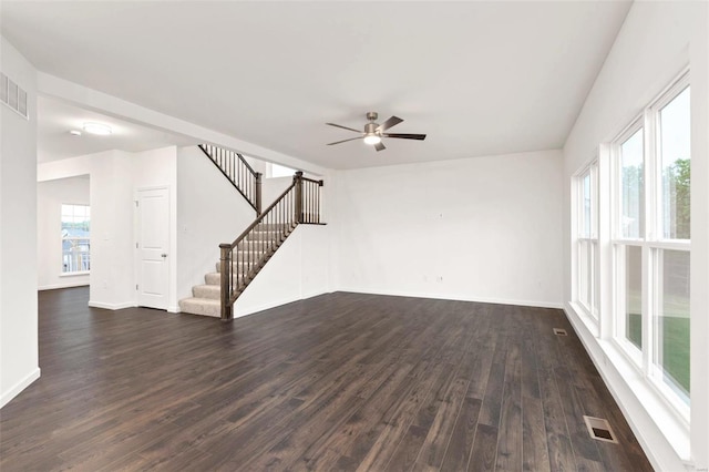 unfurnished living room featuring ceiling fan, dark hardwood / wood-style floors, and a healthy amount of sunlight