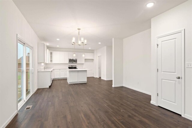 unfurnished living room with dark hardwood / wood-style floors and a chandelier