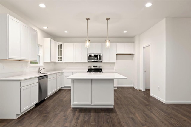 kitchen with white cabinetry, a center island, stainless steel appliances, and dark hardwood / wood-style flooring