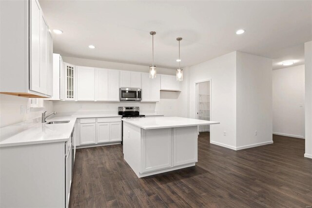 kitchen featuring white cabinetry, stainless steel appliances, dark hardwood / wood-style flooring, a center island, and sink