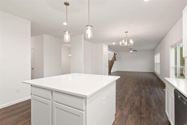 kitchen featuring a kitchen island, dark hardwood / wood-style flooring, stainless steel dishwasher, hanging light fixtures, and white cabinetry