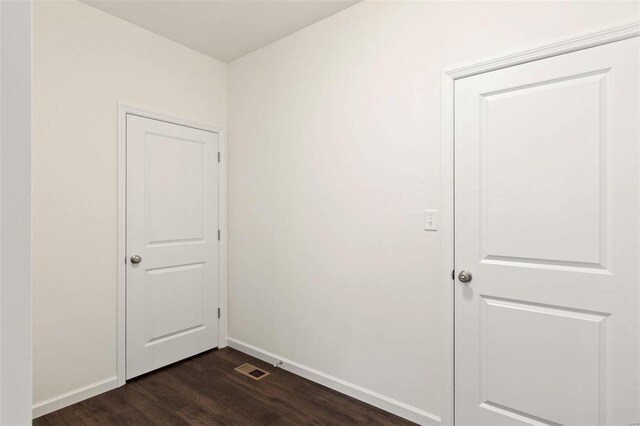 unfurnished room with dark wood-type flooring