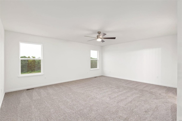 carpeted empty room with a healthy amount of sunlight and ceiling fan