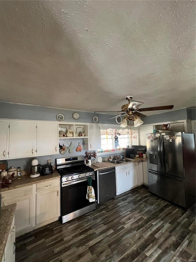 kitchen featuring white cabinets, stainless steel appliances, dark wood-type flooring, ceiling fan, and a textured ceiling