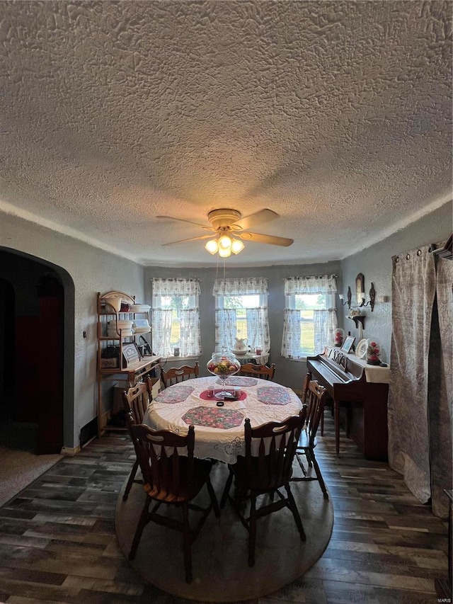 dining room featuring a textured ceiling, dark wood-type flooring, and ceiling fan