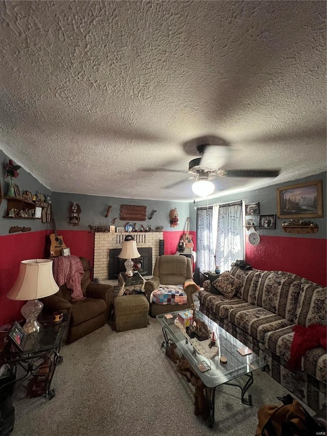 living room with ceiling fan, carpet floors, a textured ceiling, and a brick fireplace