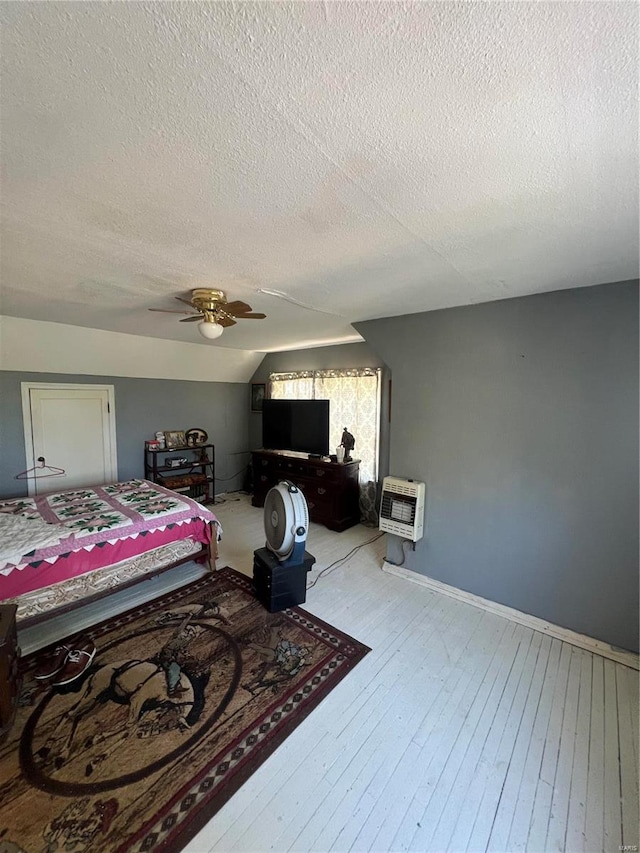 living room featuring a textured ceiling, light hardwood / wood-style flooring, heating unit, and ceiling fan