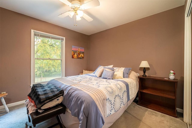 bedroom with multiple windows, ceiling fan, and light carpet