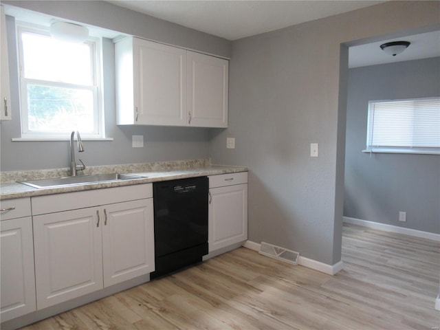 kitchen with black dishwasher, light hardwood / wood-style floors, white cabinetry, and sink