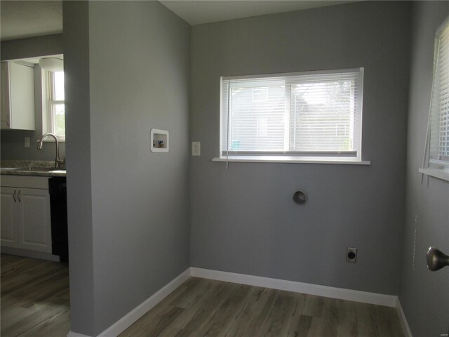 laundry area featuring electric dryer hookup, sink, washer hookup, and hardwood / wood-style flooring