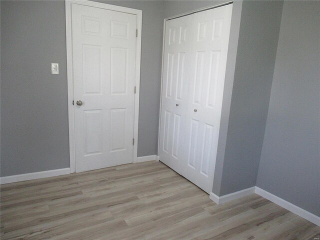 unfurnished bedroom with light hardwood / wood-style floors and a closet