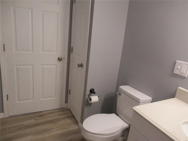 bathroom featuring vanity, hardwood / wood-style flooring, and toilet