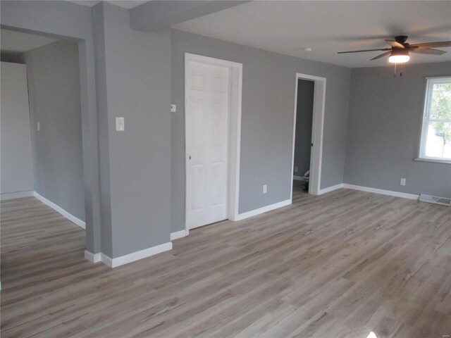 empty room with ceiling fan and light hardwood / wood-style flooring