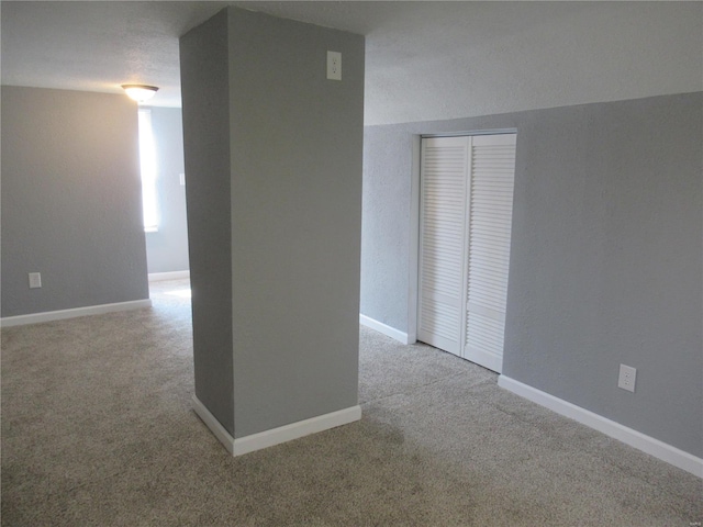 carpeted spare room with a textured ceiling