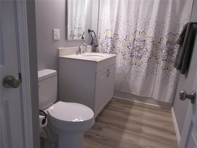 bathroom with hardwood / wood-style floors, vanity, and toilet