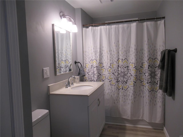 bathroom featuring vanity, wood-type flooring, and toilet