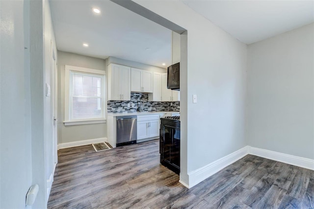 kitchen with white cabinetry, backsplash, dark hardwood / wood-style flooring, sink, and stainless steel dishwasher