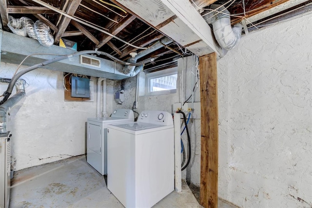 laundry room featuring electric panel and separate washer and dryer