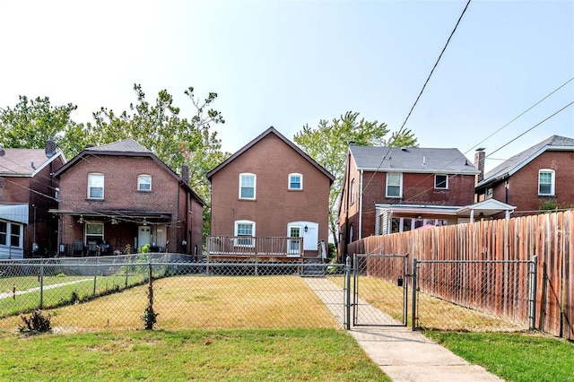 back of property with a lawn and a wooden deck